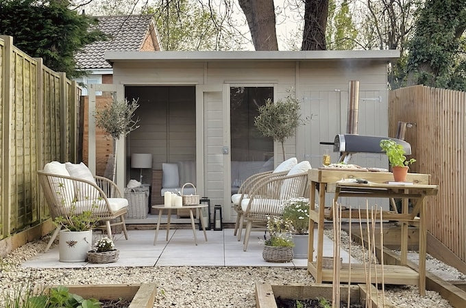 Overview of painted summerhouse with outdoor pizza kitchen and firepit