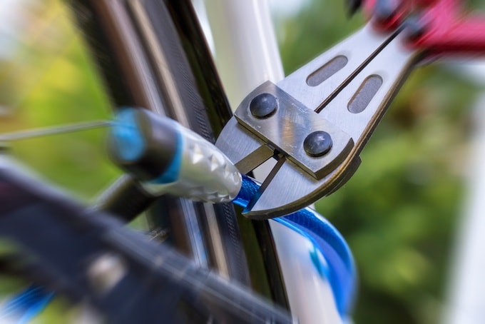 Person cutting bike lock with pliers