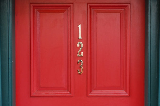 Red painted front door with numbers