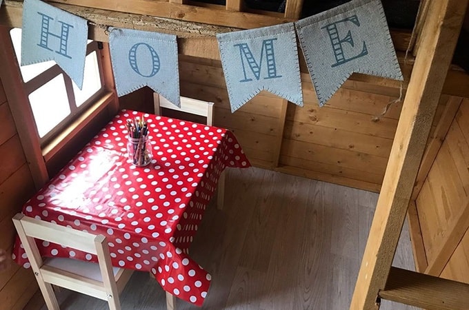 Playhouse interior with red polka dot tablecloth and banner
