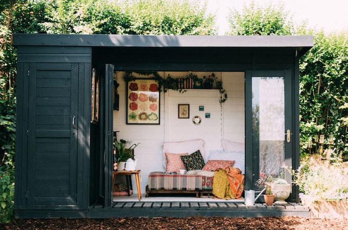 Dark coloured she-shed with cosy interior