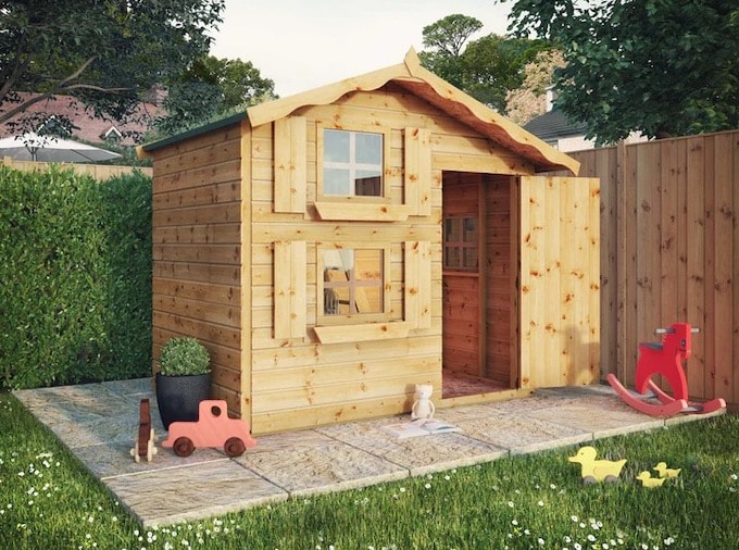 Two-storey playhouse with door open and assorted toys outside