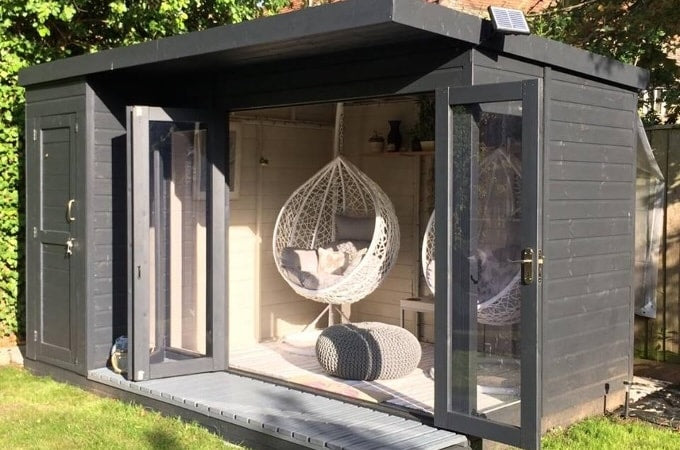 Painted summerhouse with doors open in sunshine