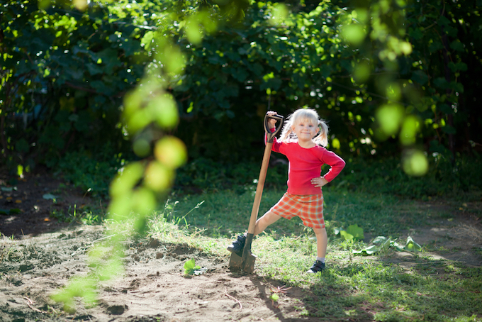 Little girl in garden with shovel