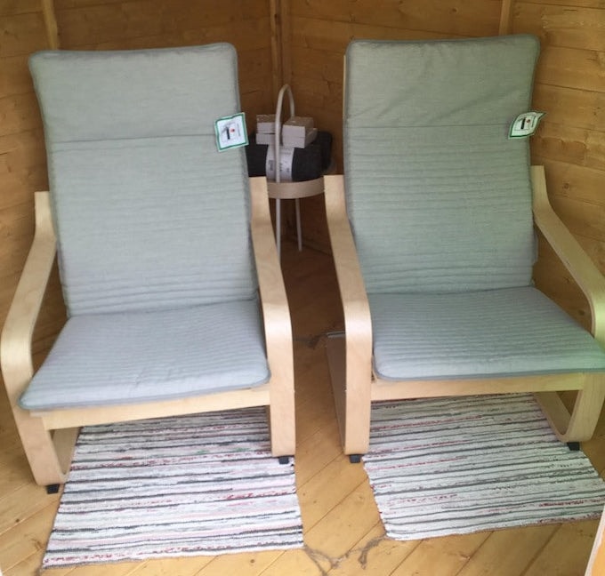 Two chairs in wooden summer house with matching rugs