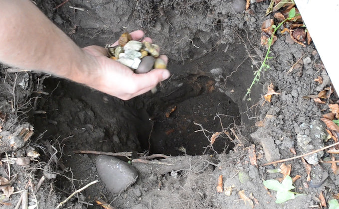 putting gravel into a fence post hole