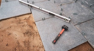 Rubber mallet being used to secure slabs