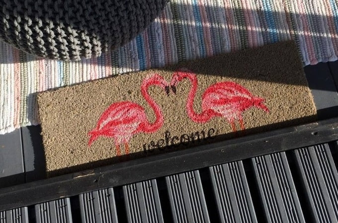 Welcome mat with flamingos outside summer house