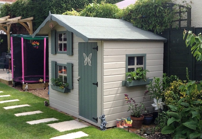 Green and white two-storey playhouse with butterfly door decoration