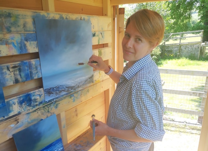 Woman painting in shed art studio
