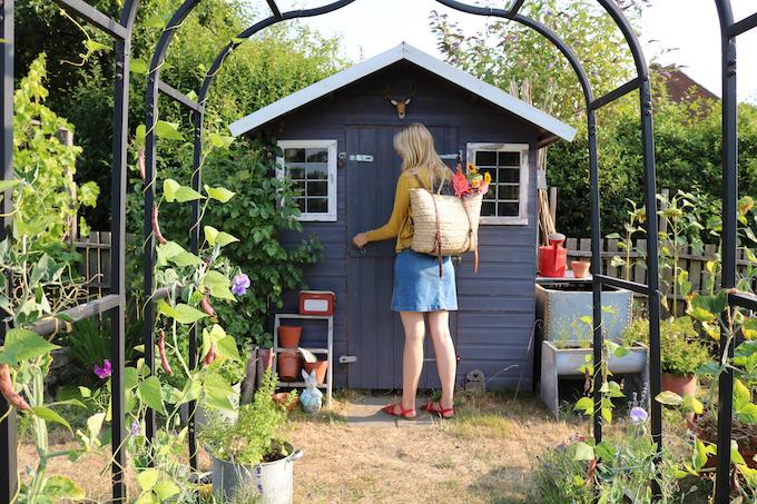 Woman standing in front of purple shed on allotment