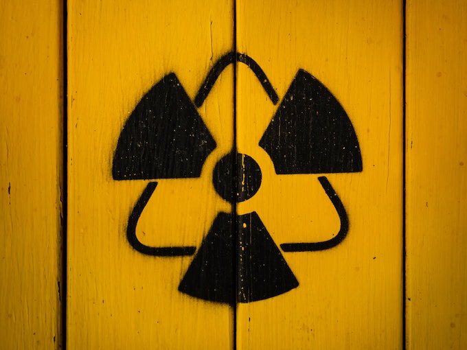 Black radioactive spray painted sign on wooden panel