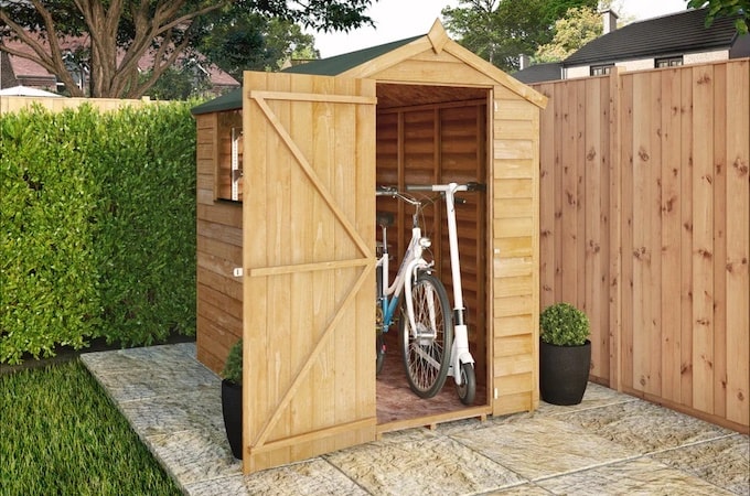 Wooden shed with doors open showing bikes