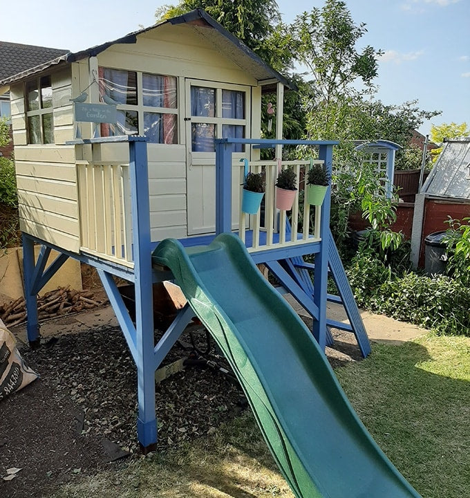 Yellow and blue tower playhouse with green plastic slide