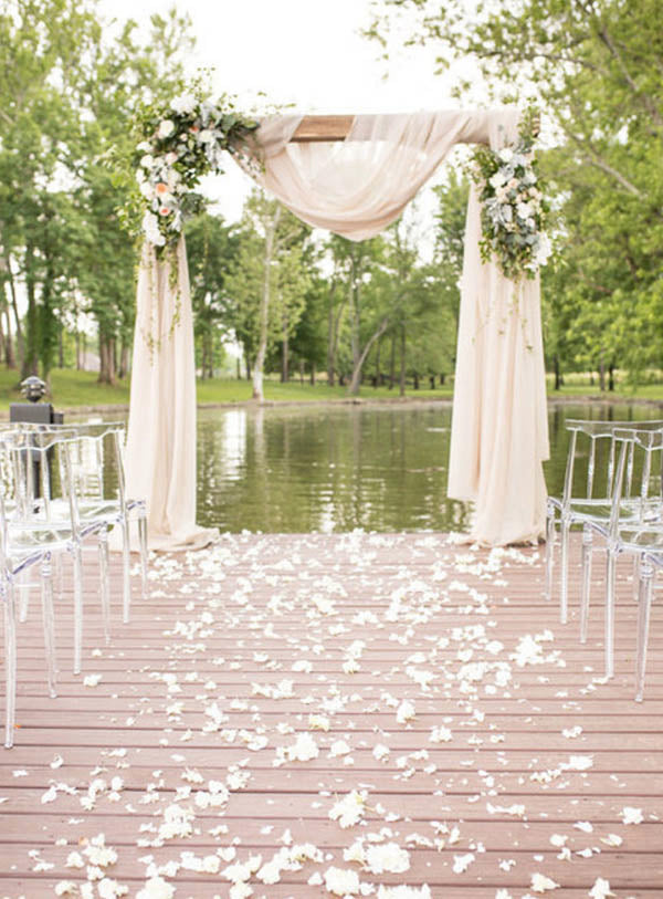 Lakeside outdoor wedding arch with pink drape and rustic flower decor