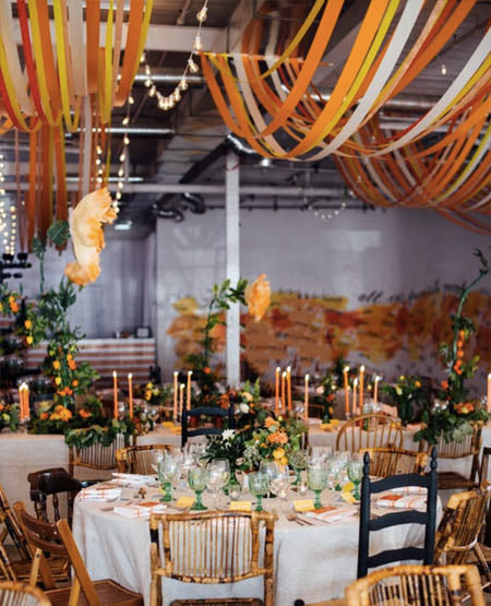 burnt orange and yellow wedding reception decoration with hanging ribbons