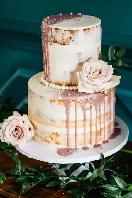 Naked wedding cake with rose gold dripping is a on-trend idea