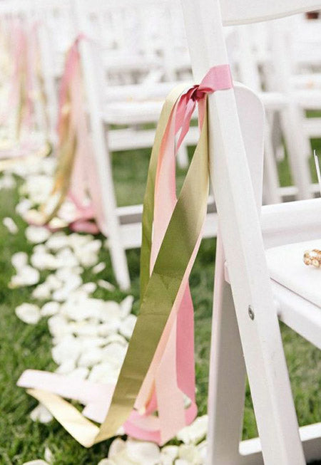 wedding aisle chair decorated with pink and green ribbons
