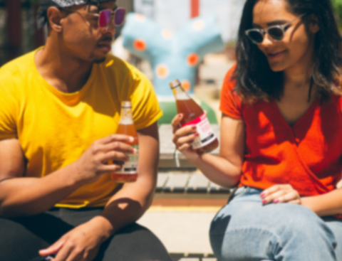 man and woman drinking bottled beverage