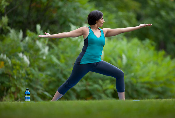 A person in a standing yoga pose outside.