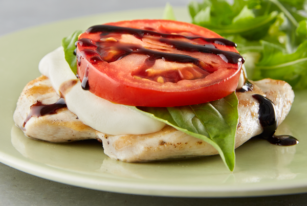 Chicken breast topped with Caprese salad.