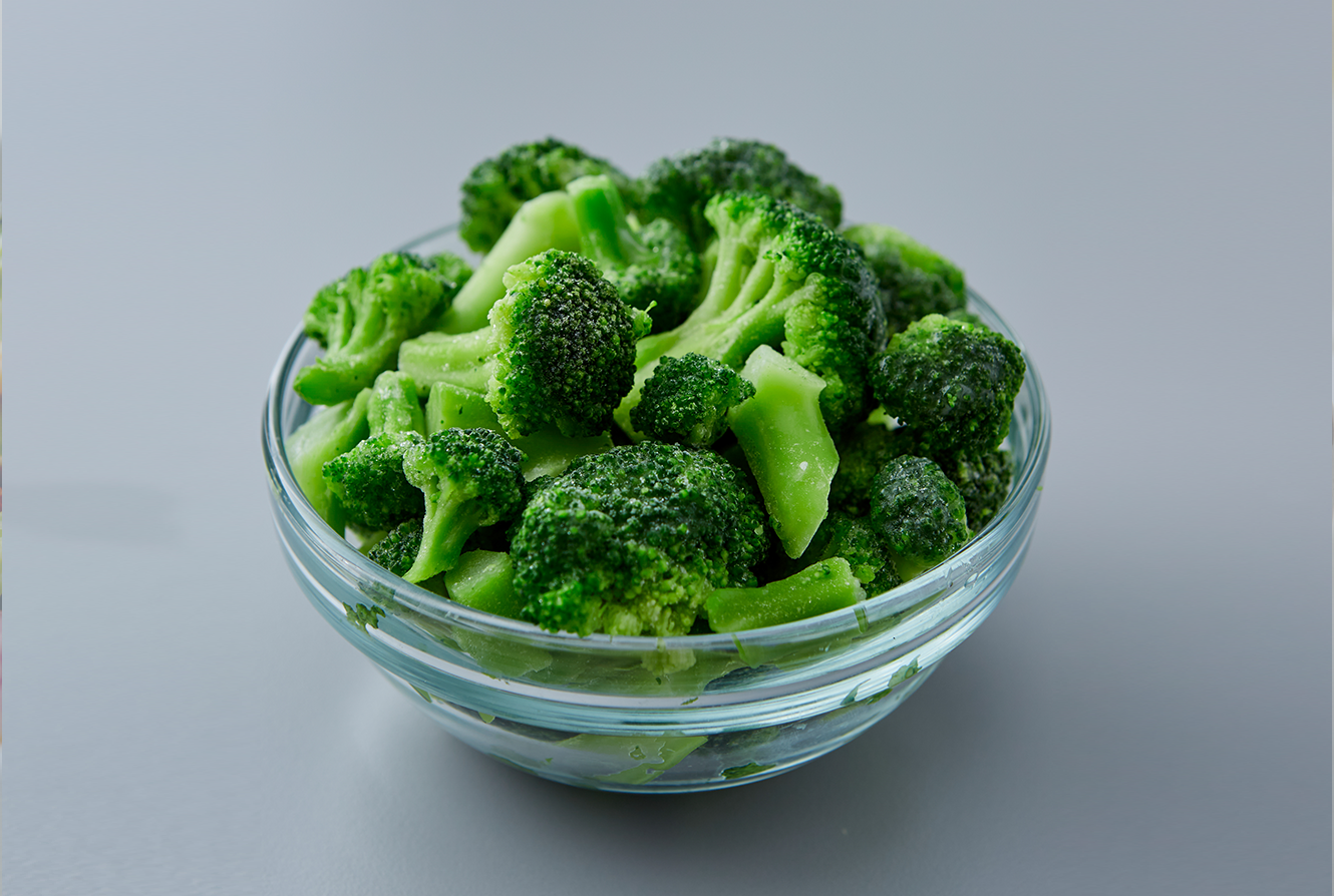 Bowl of steamed broccoli in a glass bowl.