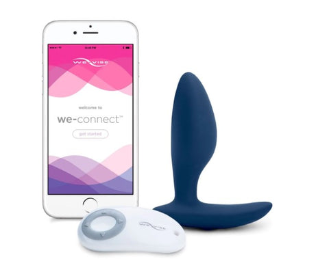 A dark blue We-Vibe Ditto butt plug next to a remote control and a smartphone