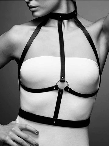 A woman wearing a white vest teamed with the faux lather body harness