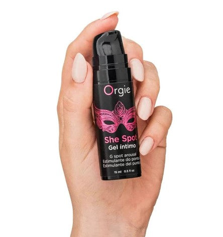 A hand holding a black & red bottle of Orgie She Spot pleasure gel