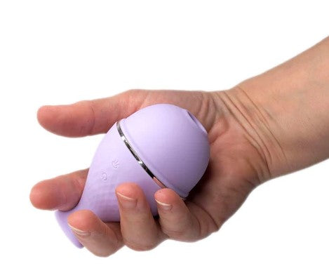 A hand holding a suction sex toy in pale lilac silicone