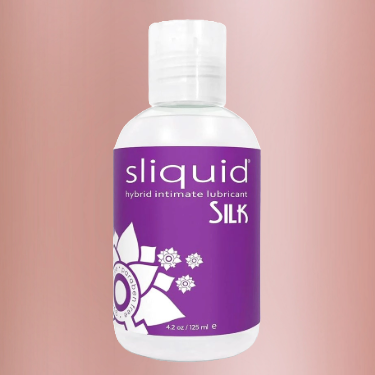 A bottle of Sliquid Natural Sil Hybrid Lube on a dusky pink background.