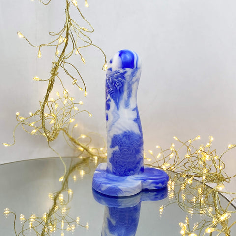 A blue and white marble dildo on a mirror
