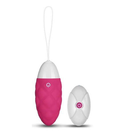 A bright pink and white love egg next to a white remote control