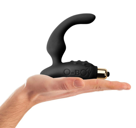 A hand holding a prostate massager in black silicone