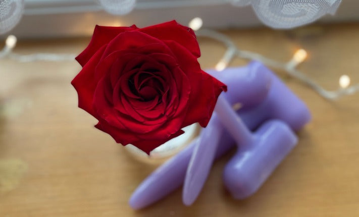 Fouyr dilators in l.ilac siicone, along with a red rose. 