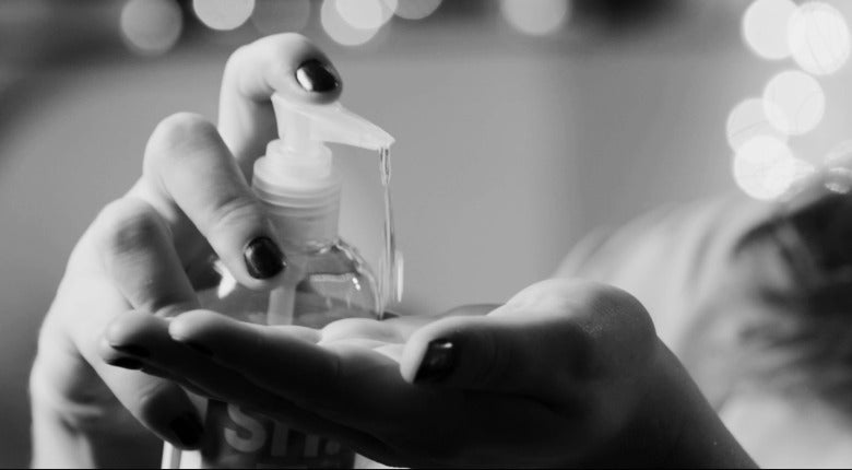 black and white image of two hand. one hand is pumping lube into the other hand.
