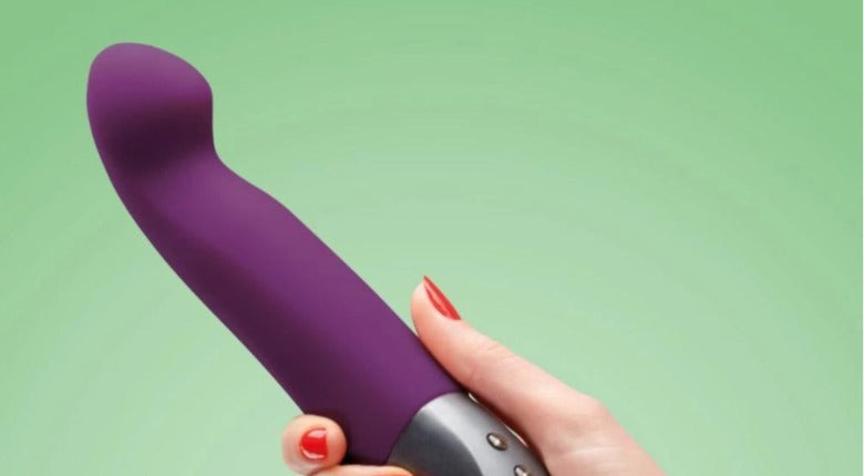 a hand with red nail varnish holding a purple G-spot vibrator