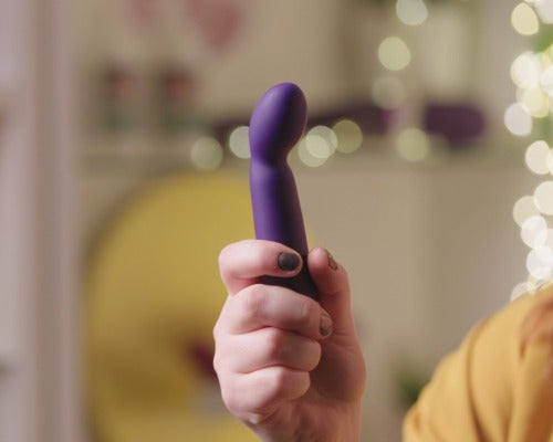 a hand holding a mid-size purple G-spot vibrator