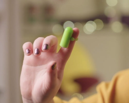 a hand with a tiny green fingertip vibrator on a finger