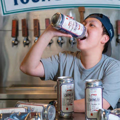 Guy throwing back a crawler of Young Master craft beer