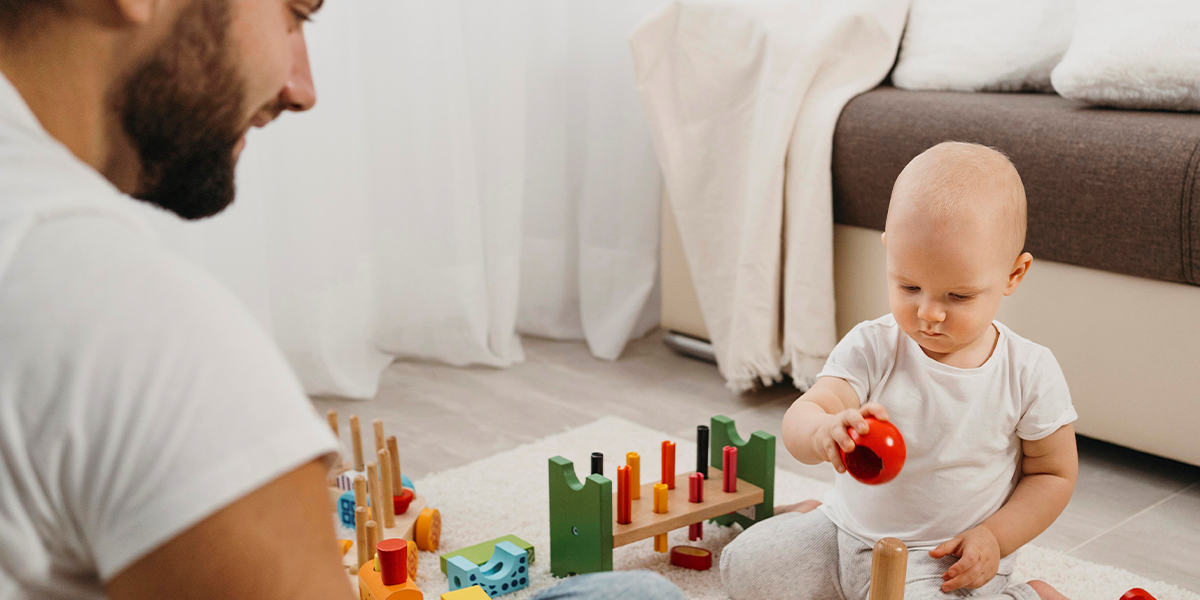 imagem de pai brincando com o bebê 