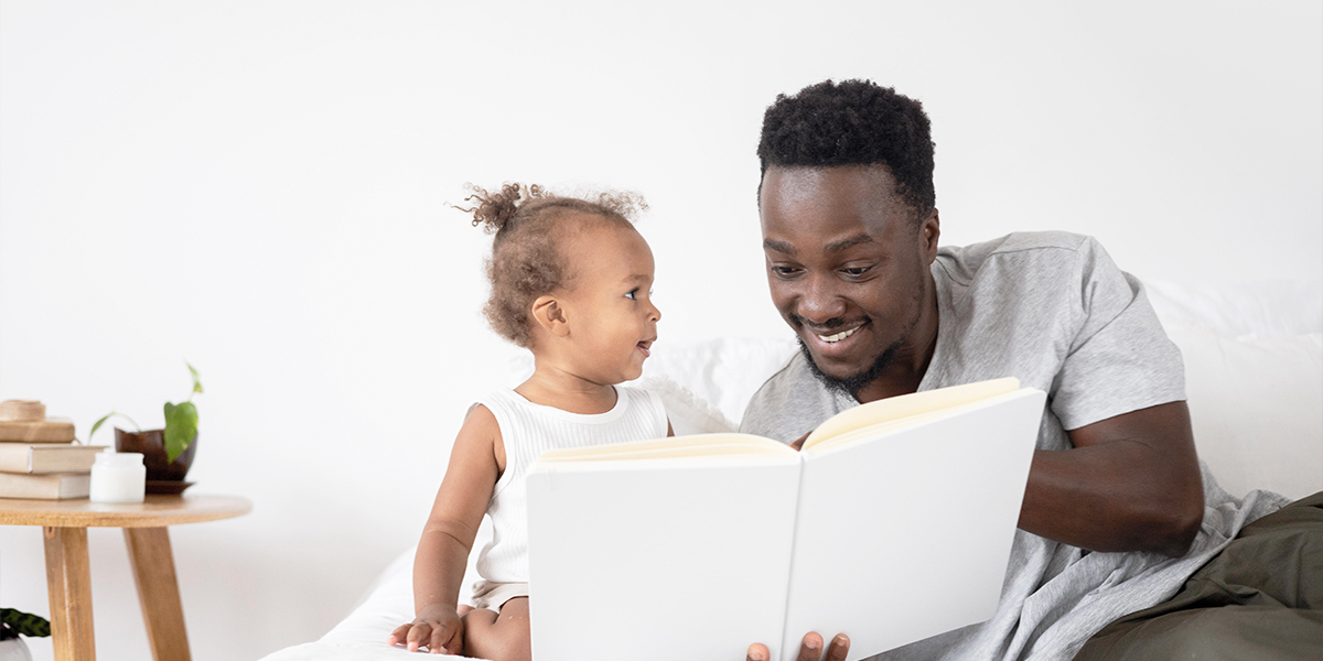 imagem de pai lendo para bebê