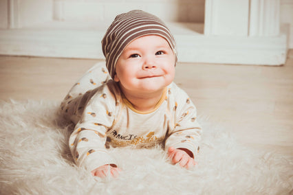 Smililng baby laying on fur rug