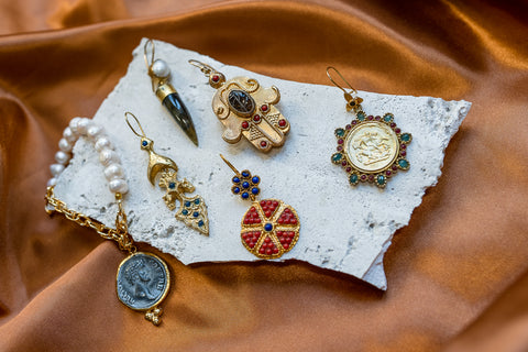 ceramic tray on satin fabric with gold, peral and gemstone earrings and bracelets