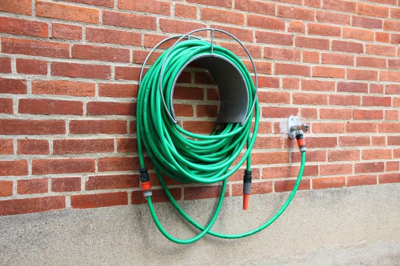 A hose rolled up on the side of a house.