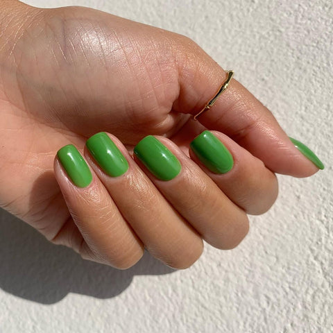 Bright green nail polish on a manicured hand