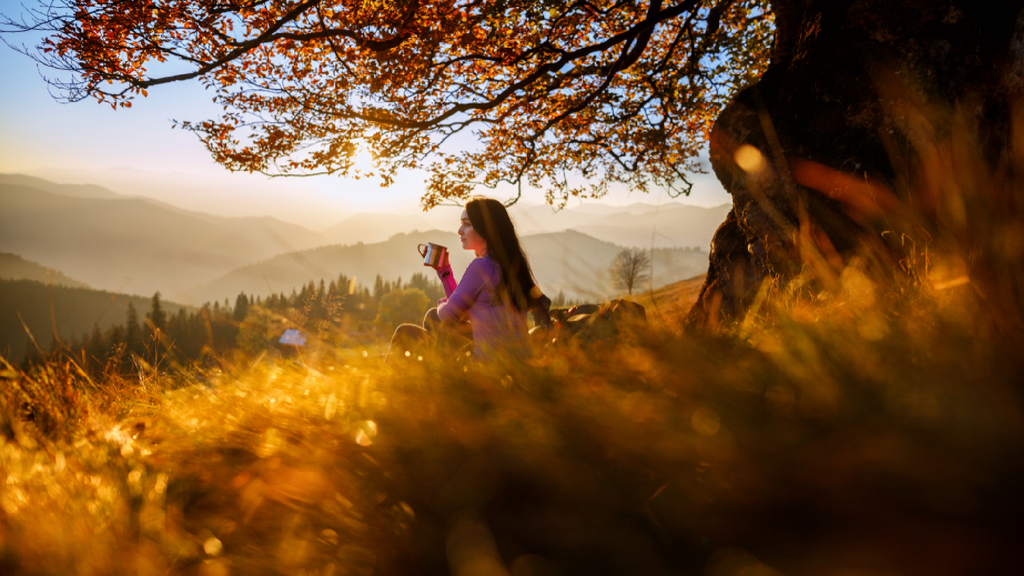 Woman on a sunset hill, drinking tea, and contemplating the health giving properties of Revogreen microgreens.