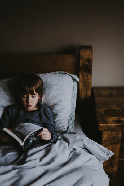 Kid reading a book before bed