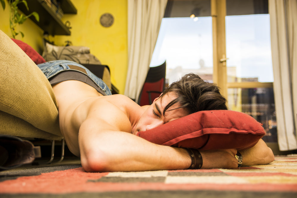 Teenager falling half off a couch, asleep