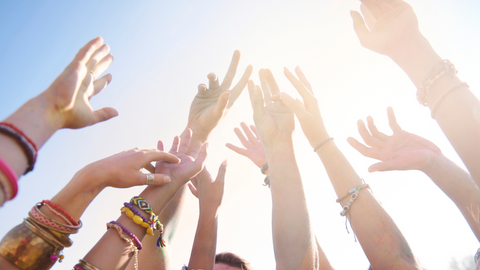 Group of friends with their arms up in the air